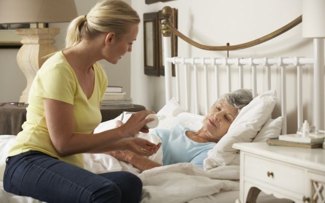 Care working giving palliative care to elderly lady