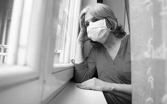 Elderly Woman With Surgical Mask Looks Out Window