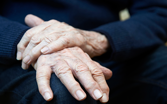 Elderly persons hands resting on lap