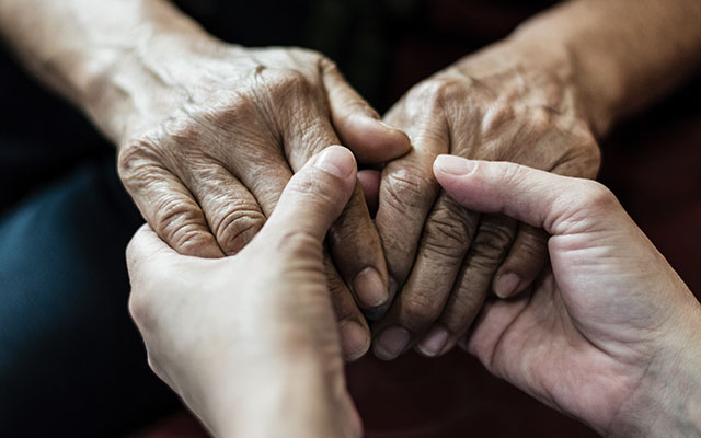 Carer holding elders hands