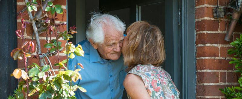 woman greeting elderly man