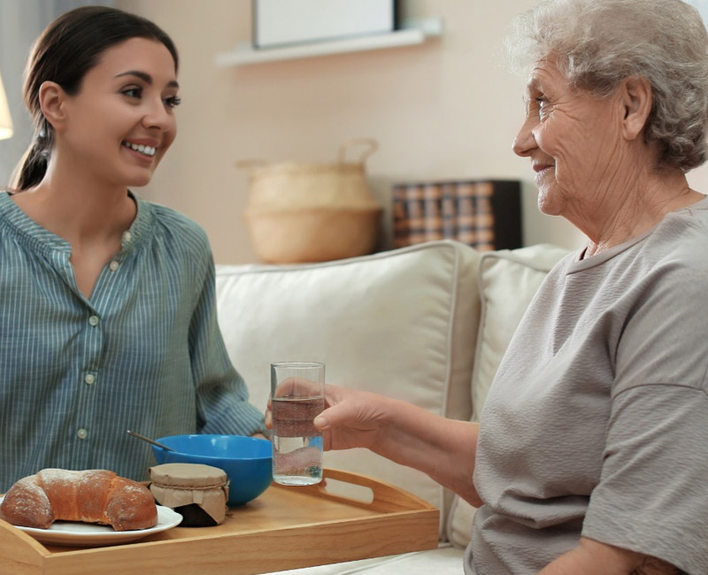 carer serving breakfast at home