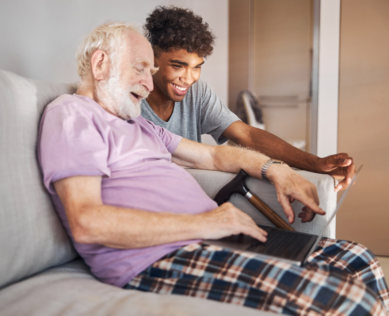 young male carer helping client with technology