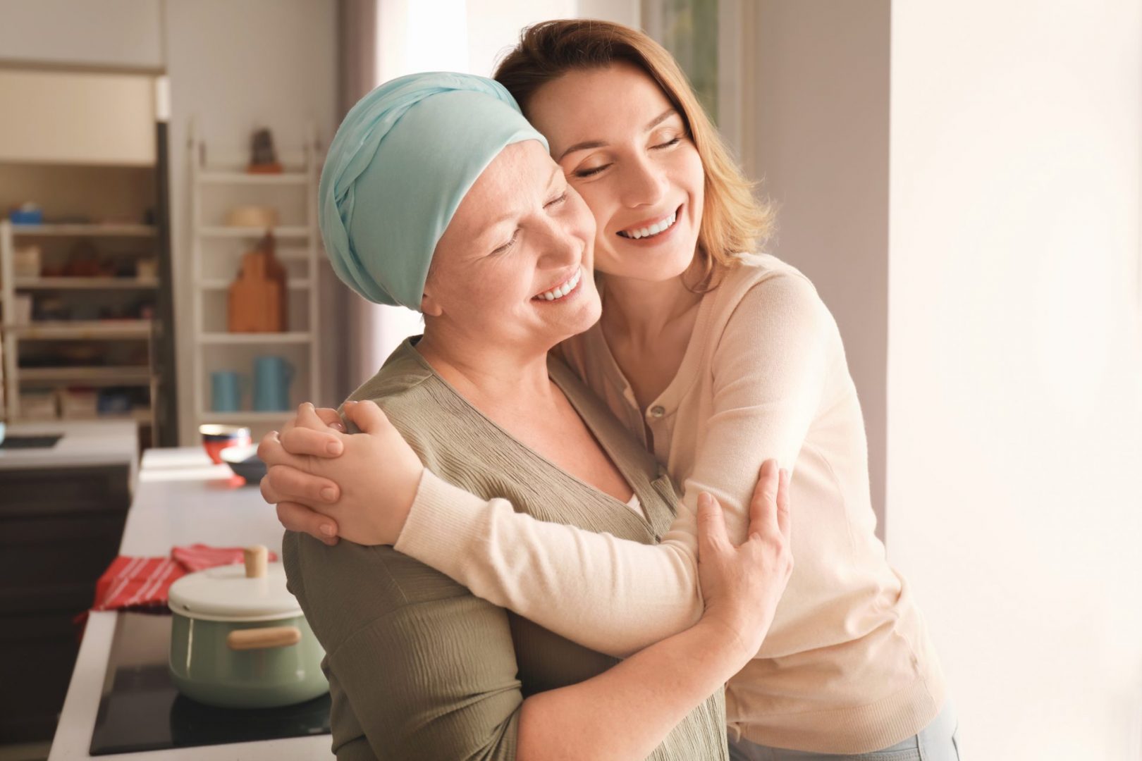 A woman receiving cancer care hugging her live-in carer.