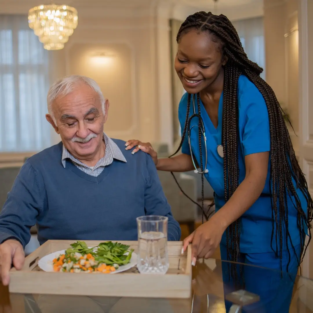 A live-in carer bringing a meal to a patient