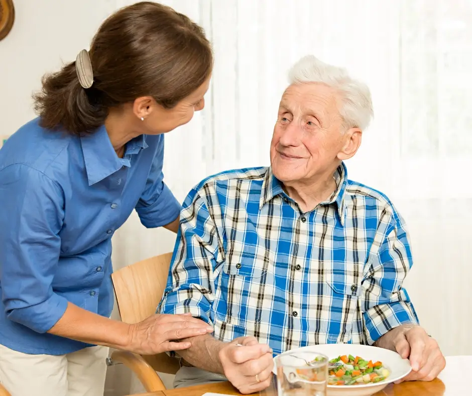 A live-in carer talking to an elderly patient